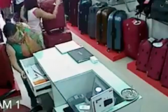 Une femme se sert dans la caisse pendant que les vendeurs ont le dos tourné Une femme se sert dans la caisse pendant que les vendeurs ont le dos tourné
