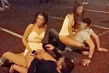 Deux couples de jeunes faisant l'amour sur le parking d'une discothèque