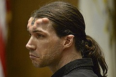 Avec des cornes de diables implantées sous la peau du front et un tatouage Avec des cornes de diables implantées sous la peau du front et un tatouage