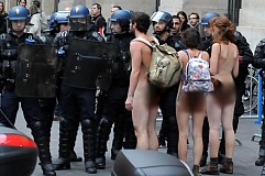 Deux femmes et un homme entièrement nus au milieu des manifestants
