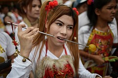 (Photos) Les adeptes chinois du végétarisme défilent, des couteaux dans le visage 